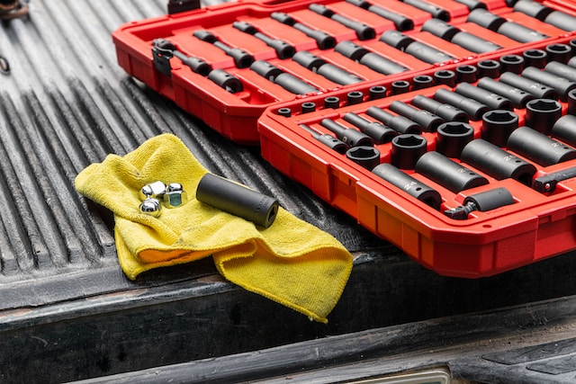 A red toolbox with different sockets and a yellow rag