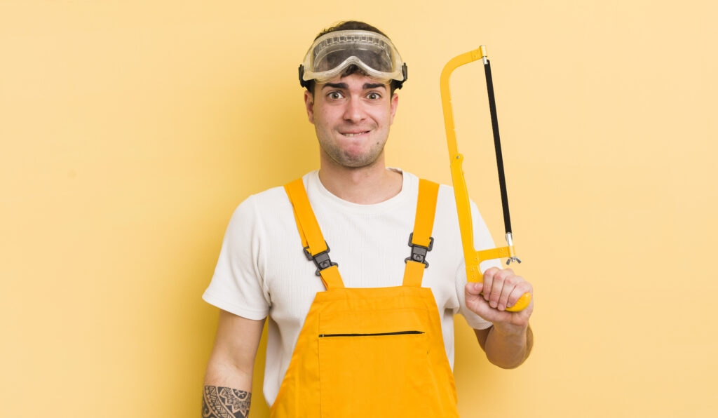 A tradie looking puzzled and self-conscious about his teeth.