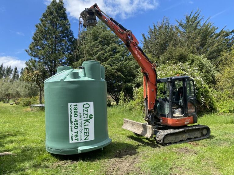 digger holding plastic septic tank