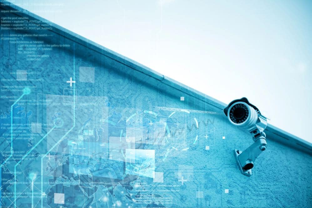 A modern security camera mounted on a commercial building wall, with digital interface graphics symbolising smart surveillance technology.