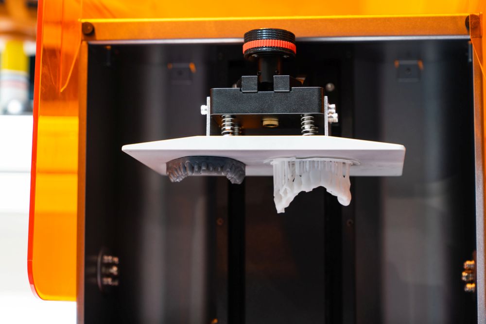 A 3D printer creating a jaw prosthesis for digital dentistry in an orthodontic lab.